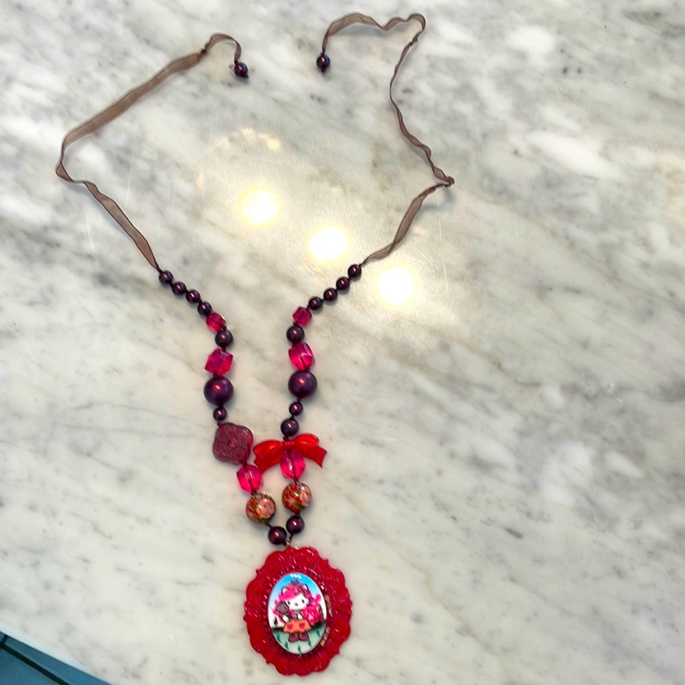 Kitty collectible necklace missing 6 red crystals( you can barely tell)